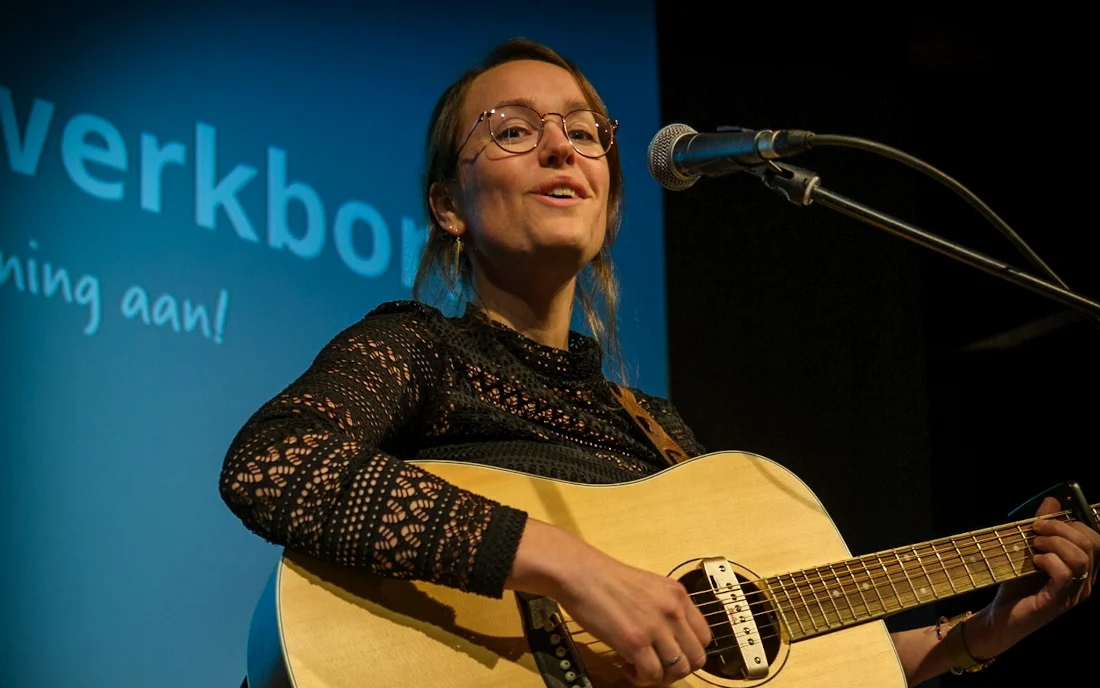Isis solo met gitaar aan de microfoon op het podium