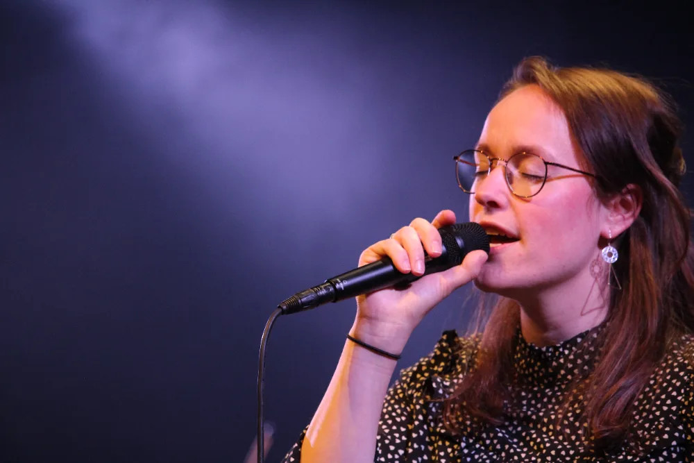 Isis zingt in een zaal met spotlicht tijdens een concert